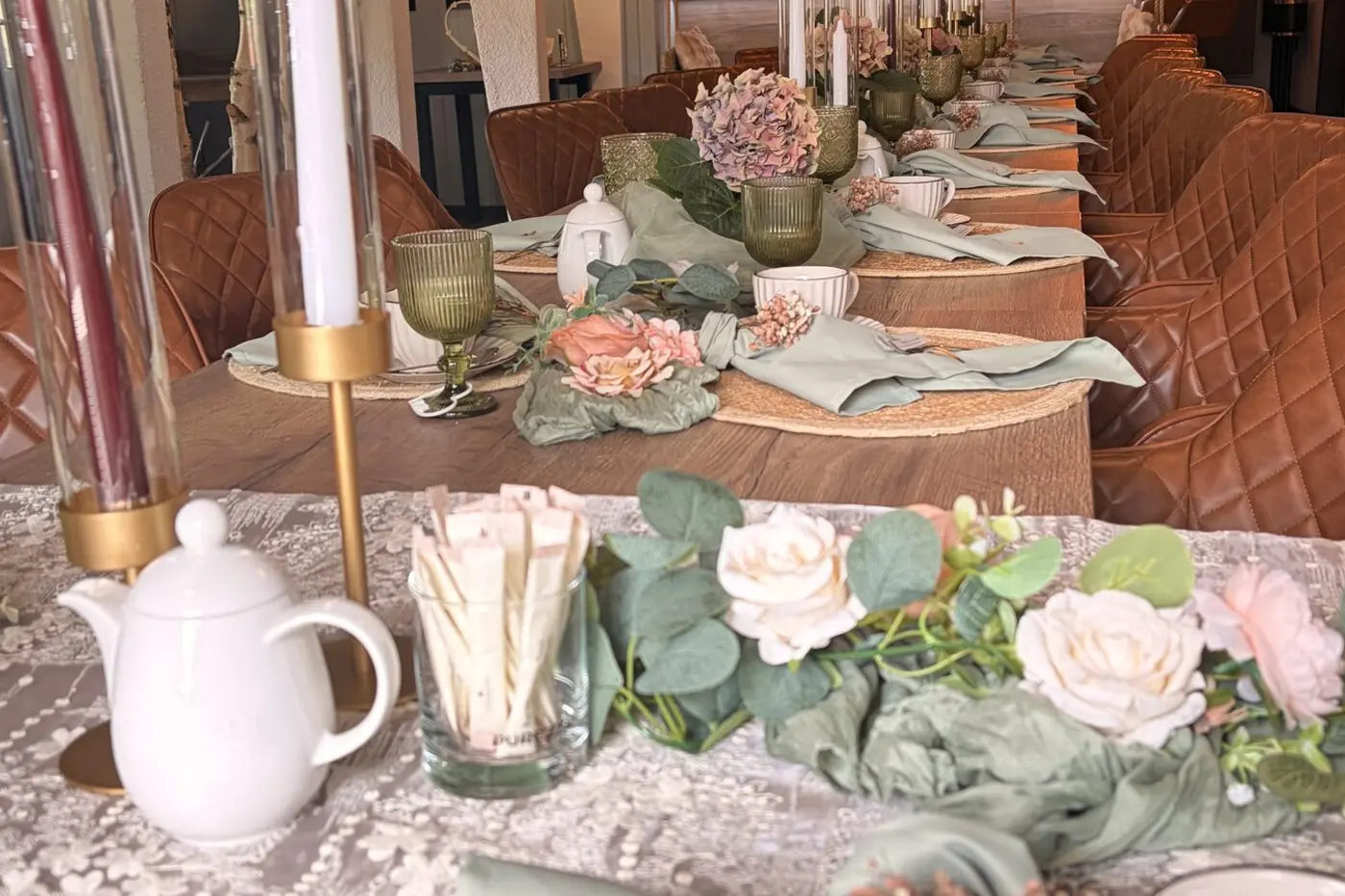 Blumen, Kerzen und Porzellan auf einer festlich gedeckten Tafel