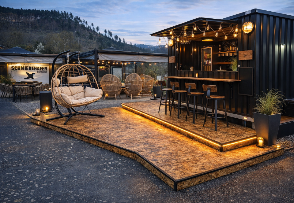 Die beleuchtete Hafenbar mit Sitzplätzen am Abend