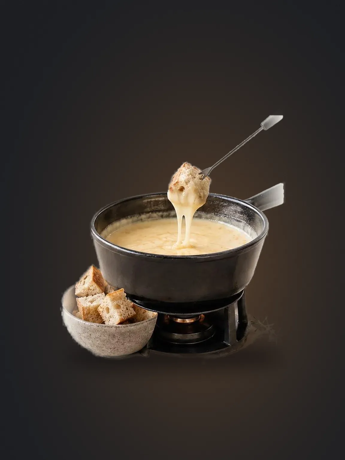 Käsefondue im gusseisernen Topf mit Brotwürfeln